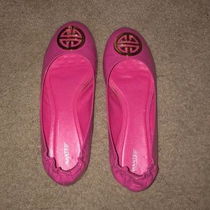 Pink patent leather flats with gold emblem on toe